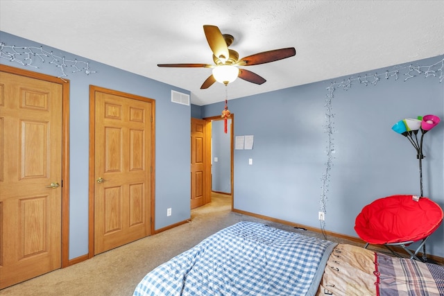 carpeted bedroom with a textured ceiling and ceiling fan