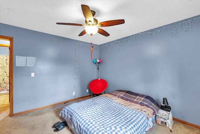 bedroom featuring ceiling fan, carpet, and a textured ceiling