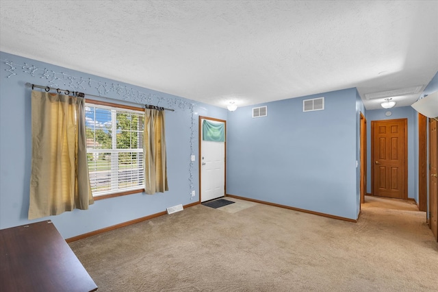 interior space featuring a textured ceiling and light colored carpet