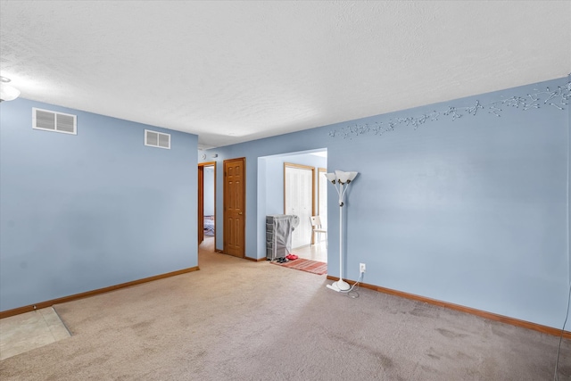 carpeted spare room featuring a textured ceiling