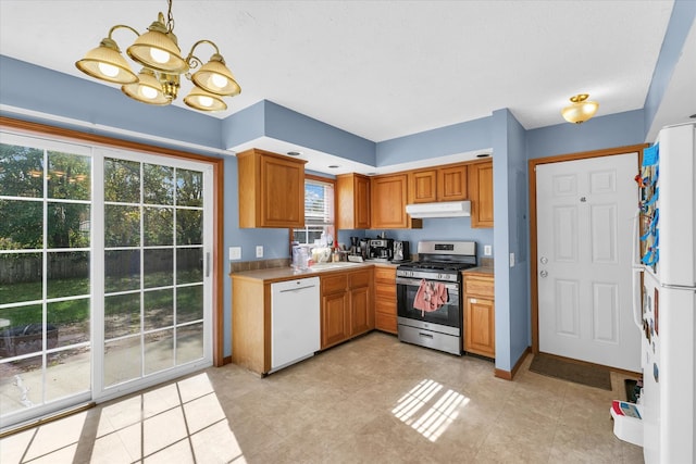 kitchen featuring white appliances, a notable chandelier, and sink