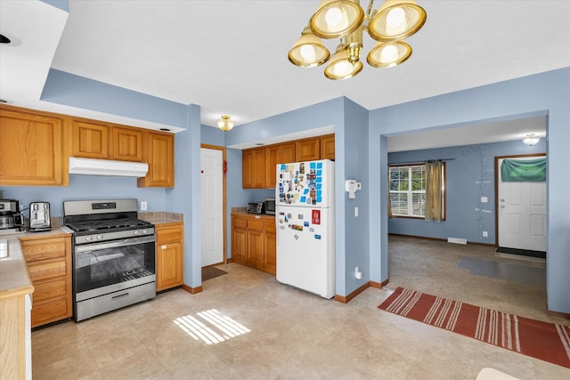 kitchen with stainless steel range with gas stovetop, white fridge, and an inviting chandelier