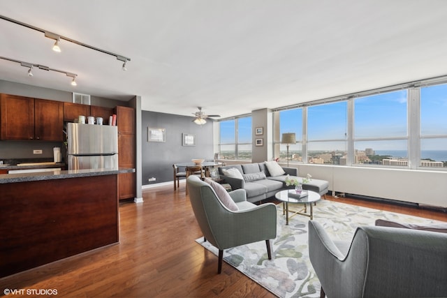 living room with ceiling fan and dark hardwood / wood-style flooring