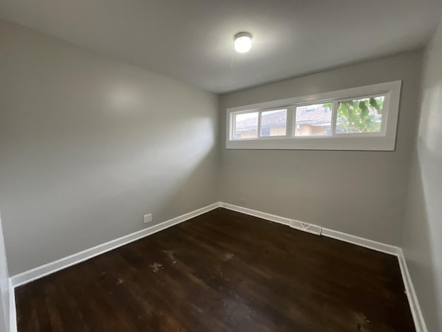 empty room with dark hardwood / wood-style flooring