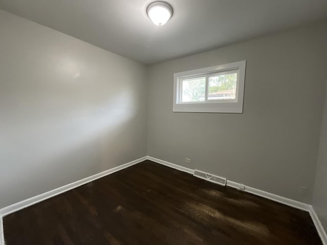 spare room with dark hardwood / wood-style flooring