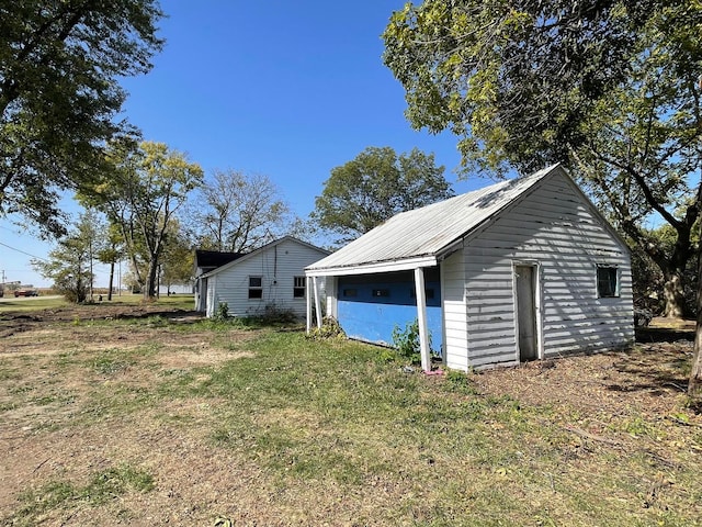 view of side of property featuring an outdoor structure and a lawn