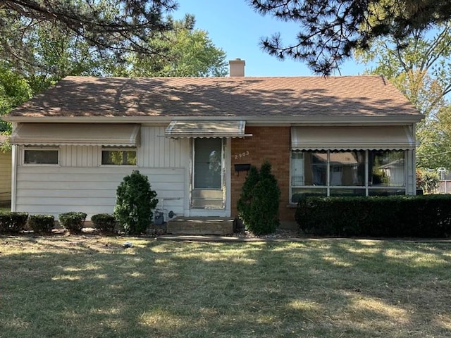 single story home featuring a front lawn