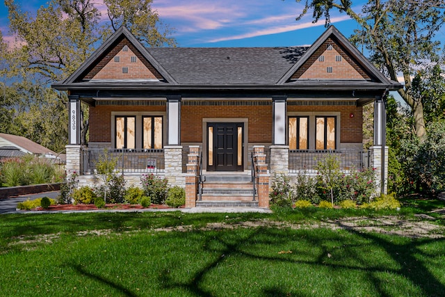 view of front of house featuring covered porch and a lawn