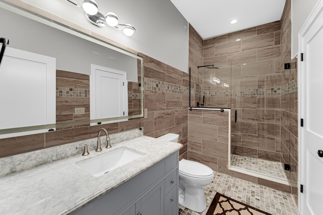 bathroom featuring tile patterned floors, a shower with shower door, vanity, and toilet