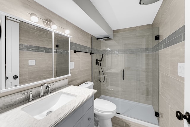 bathroom featuring an enclosed shower, tile walls, vanity, and toilet