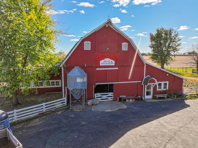 view of barn featuring fence