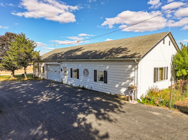 view of front facade with aphalt driveway and roof with shingles