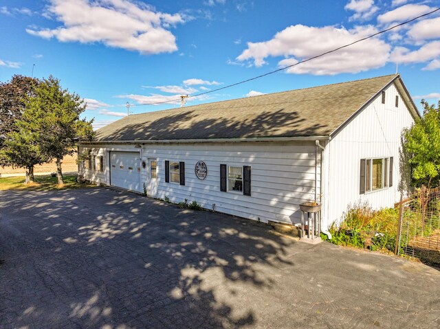 11971 W E Rd, Forreston, IL 61030 - view of front facade featuring asphalt driveway and roof with shingles