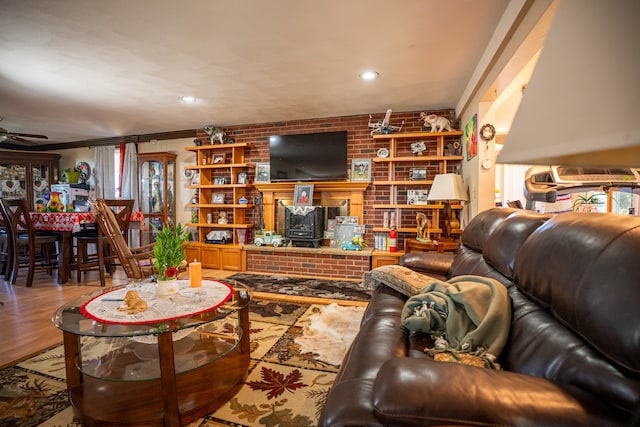 living area featuring brick wall, a ceiling fan, wood finished floors, and recessed lighting