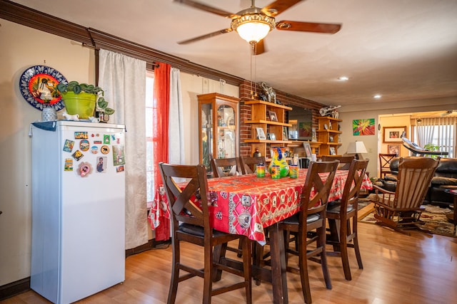 dining space featuring ceiling fan, crown molding, and wood finished floors