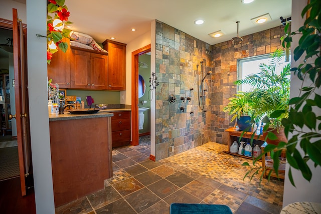 full bathroom with recessed lighting, stone tile floors, a walk in shower, and vanity