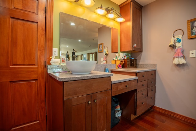 bathroom with wood finished floors, vanity, and baseboards