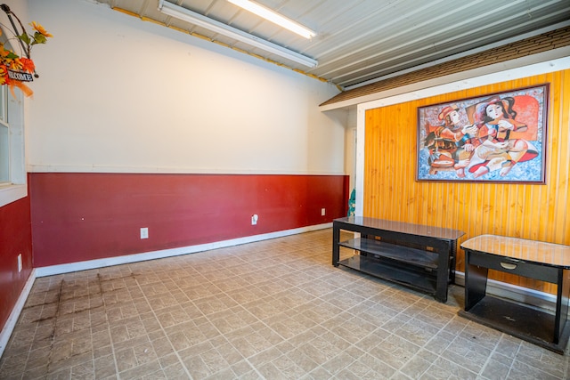 living area featuring baseboards and wooden walls