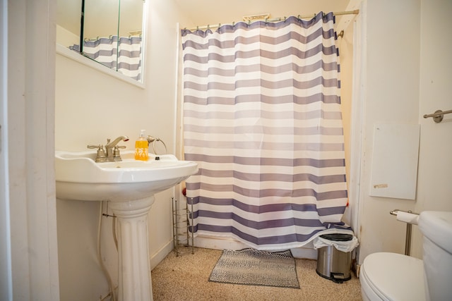 bathroom featuring toilet, a shower with curtain, a sink, and speckled floor