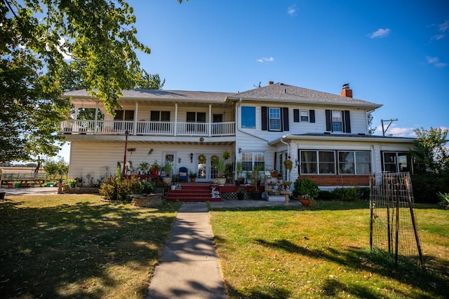 11971 W E Rd, Forreston, IL 61030 - view of front of property with a chimney, a balcony, a front yard, and brick siding