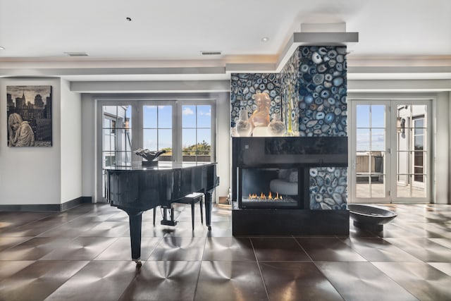 misc room with french doors, a stone fireplace, and a wealth of natural light