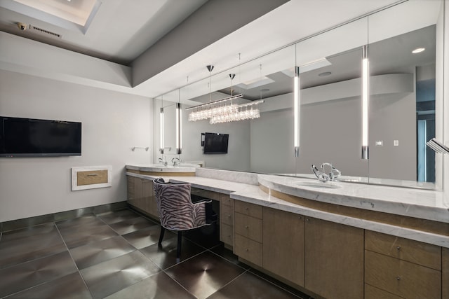 bathroom featuring vanity, an inviting chandelier, and a raised ceiling