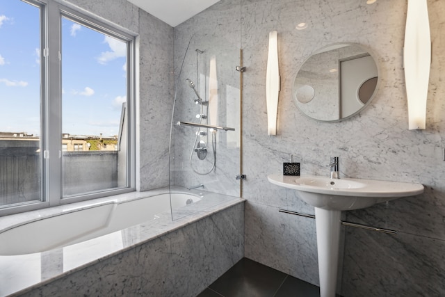 bathroom featuring tile patterned floors, tiled shower / bath combo, and tile walls