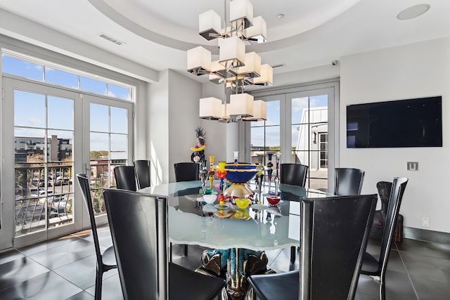 dining area featuring french doors, a notable chandelier, and a raised ceiling