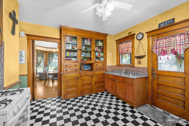 kitchen featuring white range with gas cooktop, ceiling fan, and sink