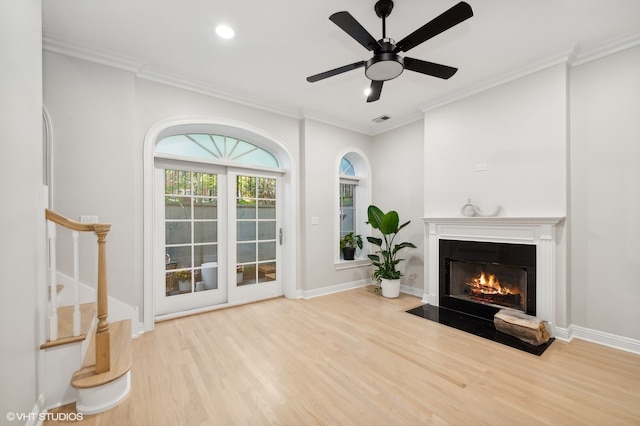 living room with light hardwood / wood-style flooring, ceiling fan, and crown molding