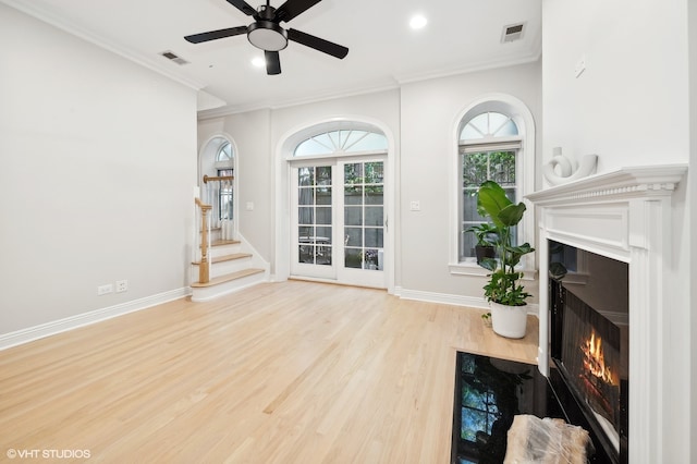 unfurnished living room with light hardwood / wood-style flooring, ornamental molding, and ceiling fan