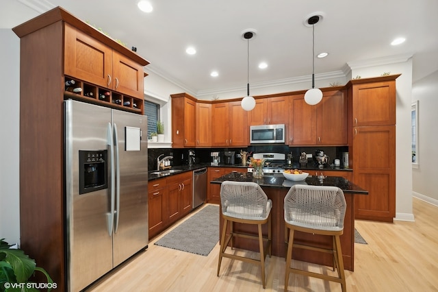 kitchen featuring a kitchen island, stainless steel appliances, sink, decorative light fixtures, and tasteful backsplash