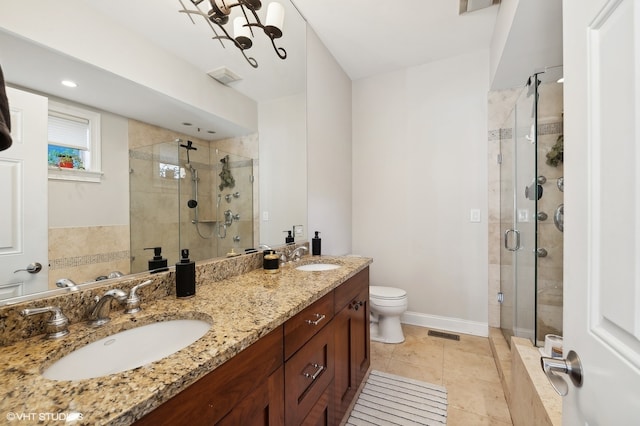 bathroom featuring toilet, walk in shower, vanity, and tile patterned floors