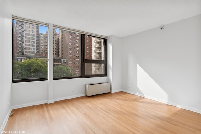 unfurnished room with radiator and light hardwood / wood-style floors