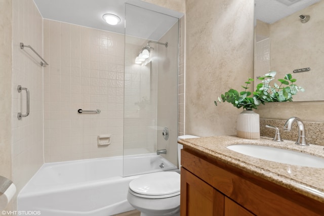 full bathroom featuring tiled shower / bath, vanity, and toilet