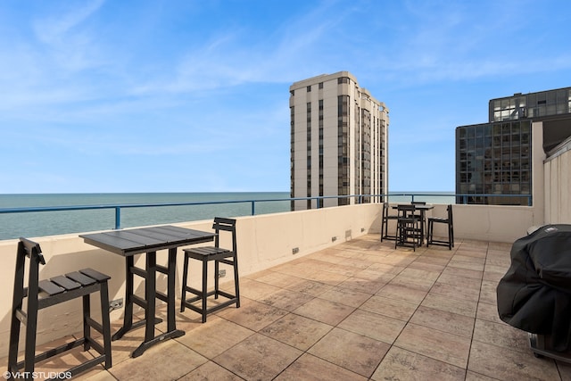 view of patio featuring a water view and a grill