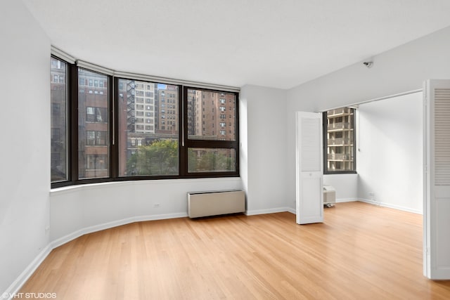 unfurnished bedroom featuring light hardwood / wood-style floors and radiator