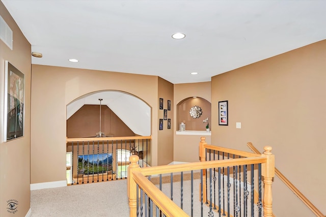 hallway featuring carpet floors and vaulted ceiling