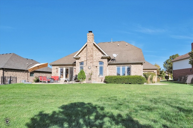 rear view of house featuring a patio and a yard