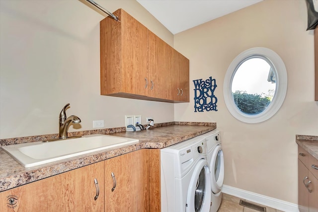 laundry area featuring separate washer and dryer, sink, light tile patterned floors, and cabinets