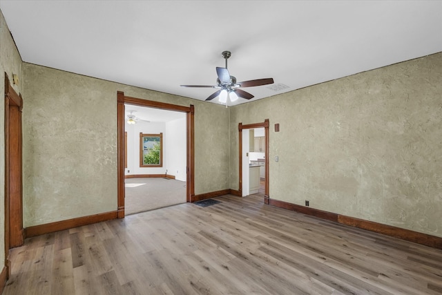 empty room with light hardwood / wood-style floors and ceiling fan