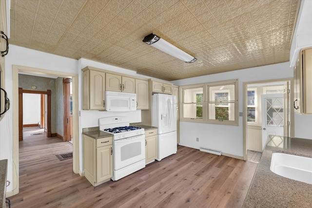 kitchen with white appliances, light hardwood / wood-style floors, cream cabinets, and baseboard heating