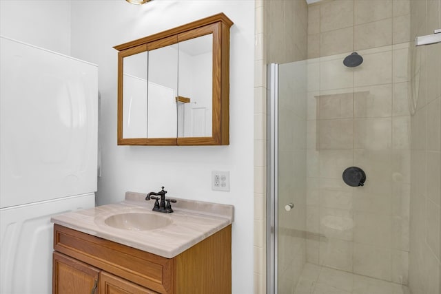 bathroom featuring an enclosed shower, stacked washer / dryer, and vanity