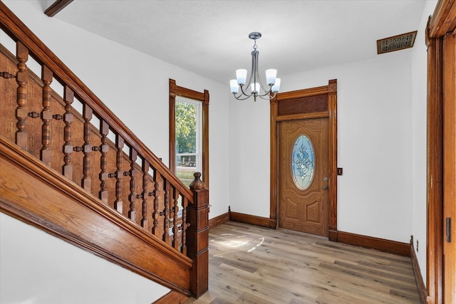 foyer entrance featuring a notable chandelier and hardwood / wood-style floors