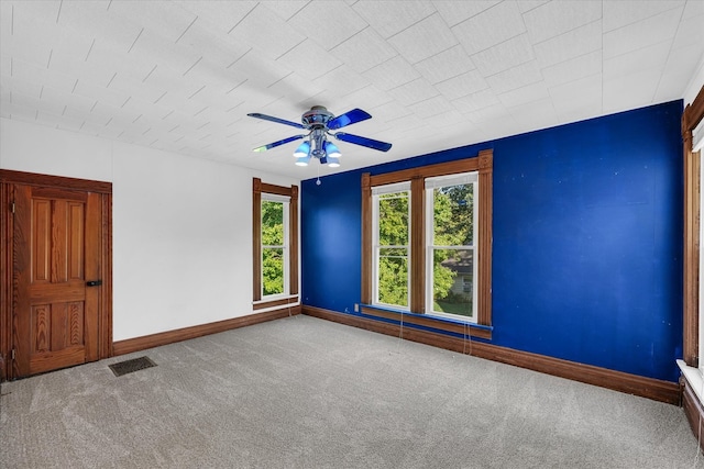 spare room featuring ceiling fan, carpet, and a healthy amount of sunlight