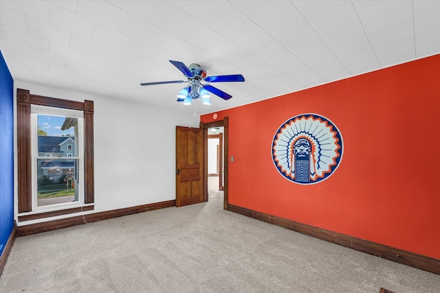 carpeted spare room featuring ceiling fan