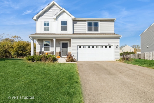 view of property with a front lawn, a garage, and covered porch