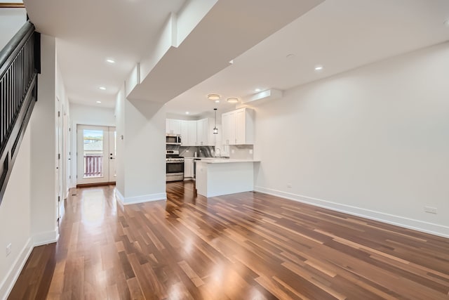 unfurnished living room with dark hardwood / wood-style floors and sink