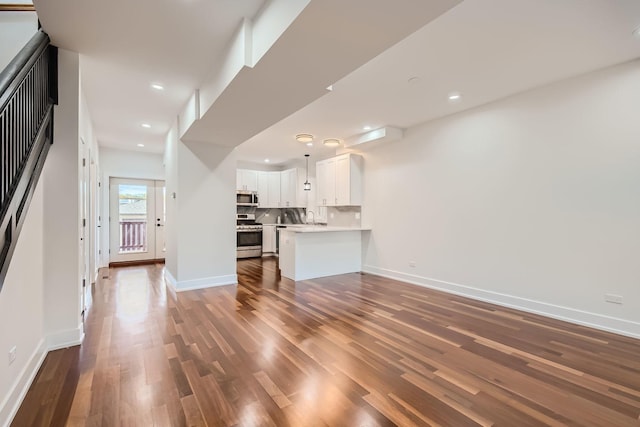 8513 S Maryland Ave, Chicago, IL 60619 - unfurnished living room with recessed lighting, dark wood-type flooring, baseboards, and a sink