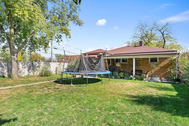 view of yard with a trampoline and a patio area